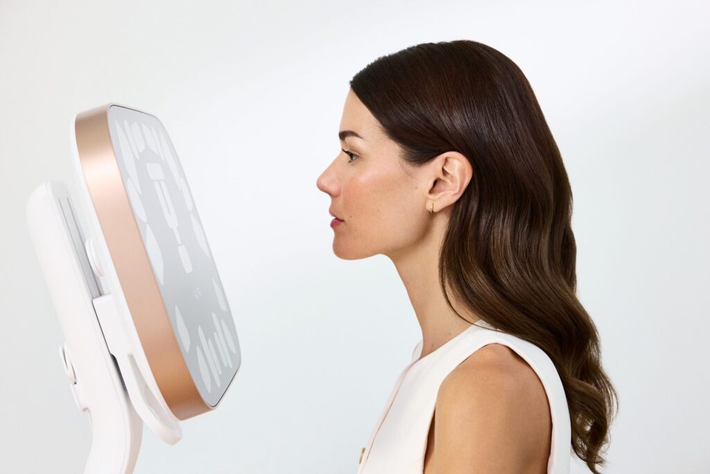 Woman in profile beside the Aura Reality face scanner