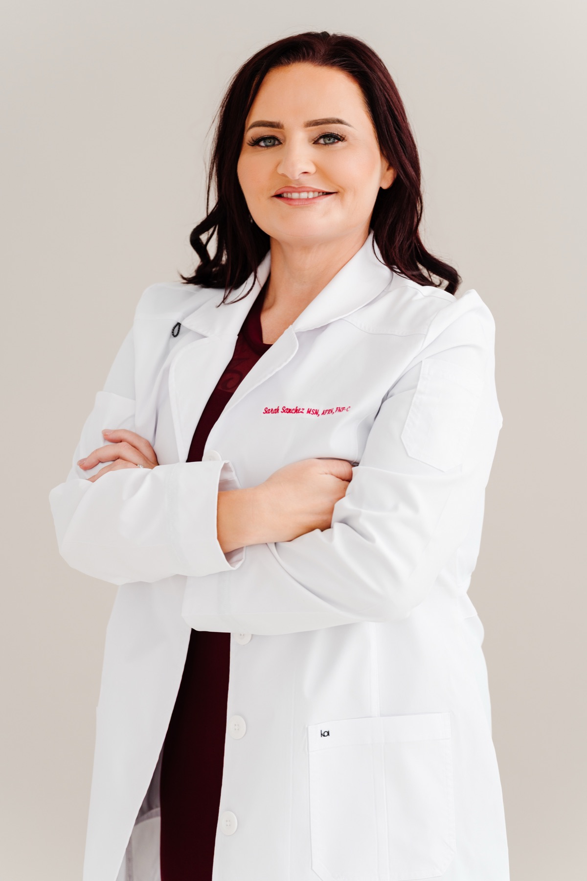 Sarah Sanchez, FNP-C, nurse practitioner, in a white coat