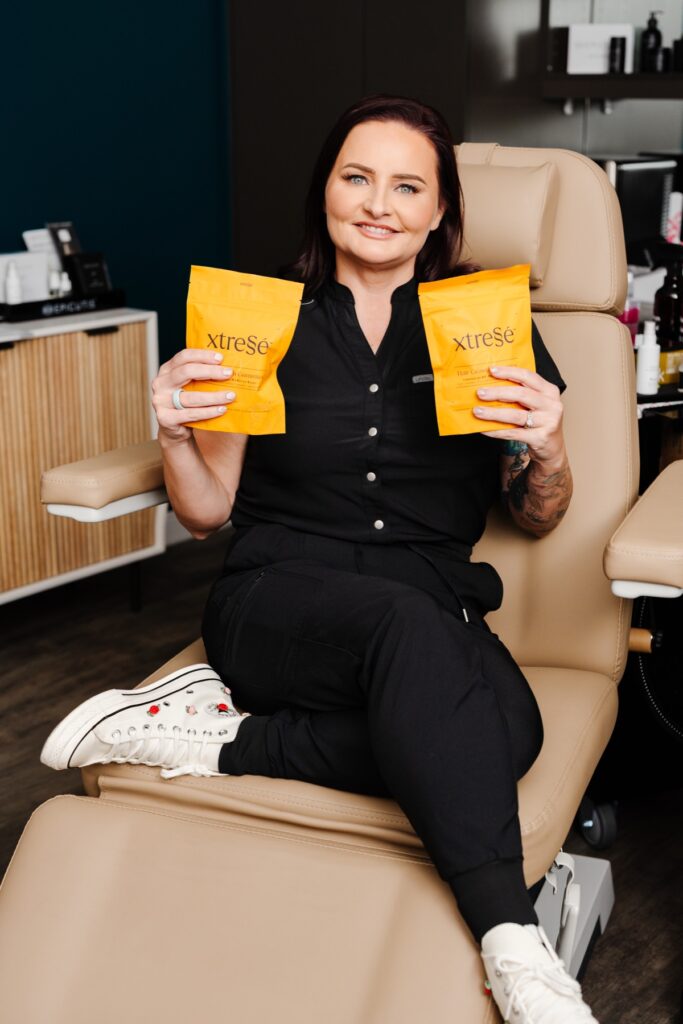 Sarah Sanchez holding Xtresse hair supplements